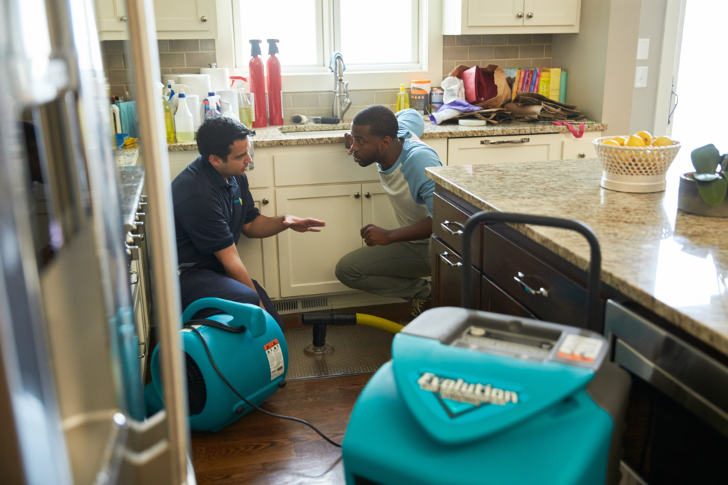 Two men talking around drying equipment
